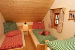 a small attic room with two beds and a teddy bear at Alpine-Lodges Matthias in Hintersauerwald