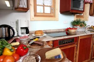 a kitchen with a counter top with fruits and vegetables at Alpine-Lodges Matthias in Hintersauerwald