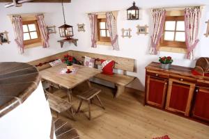 a room with a table and chairs and windows at Alpine-Lodges Matthias in Hintersauerwald +6 photos