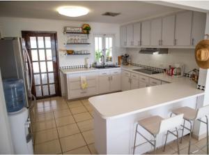 a kitchen with white cabinets and a white counter top at Family Beach House with an Amazing Ocean View in Naguabo