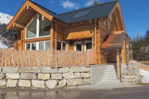 a log cabin with a stone wall and a house at Chalet Alteck in Rauris