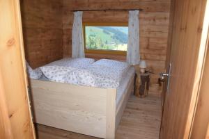 a small bedroom with a bed with a window at Achtchalet in Grossarl