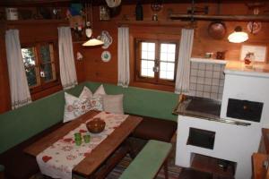 a living room with a table and a stove at Hexenhäuschen in Bachwinkl +5 photos
