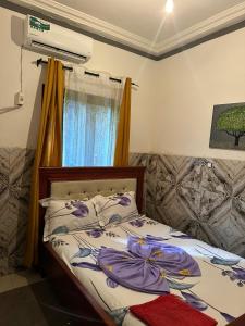 ein Schlafzimmer mit einem Bett und einem Fenster in der Unterkunft Skyatlantic guesthoüse in Douala + 7 Fotos