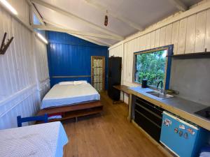 een kamer met een bed en een wastafel in een kamer bij Cabana da palmeira in Piçarras