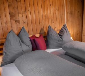 a bed with gray sheets and pillows on it at Artlieb Hütte in Maschl