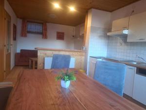 a kitchen with a wooden table and blue chairs at Schlickhütte in Schied +8 photos