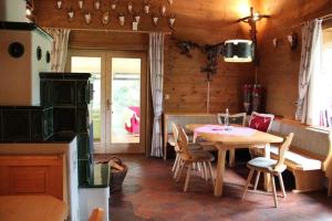 a kitchen with a table and chairs in a room at Alpine-Lodges Petra in Hintersauerwald