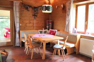 a dining room with a wooden table and chairs at Alpine-Lodges Petra in Hintersauerwald