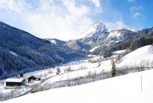 a snow covered mountain with a house in the foreground at Loimoarhütte in Bischofshofen