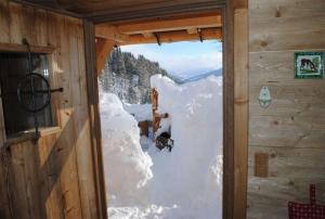 a window in a cabin with snow on the door at Loimoarhütte in Bischofshofen +15 photos