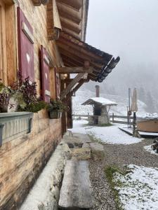 a wooden building with snow on the side of it at Loimoarhütte in Bischofshofen
