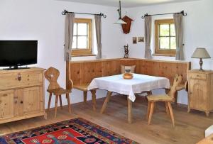 a dining room with a table and chairs and a tv at Bergchalet Klausner Kuschelsuite in Ramsberg