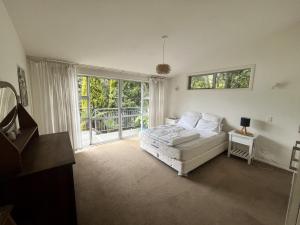 a living room with a white couch and a window at Beachfront Tranquility in Tikao Bay in Wainui