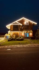 a house with lights on the front of it at night at Pousada dos Pássaros in Gramado
