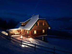 a house in the snow at night with lights at Kotmarhütte in Gräbern