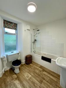 a bathroom with a toilet and a tub and a sink at Cosy Cottage on the Whisky Trail in Haugh of Glass
