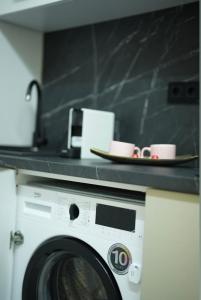 een wasmachine met twee kopjes erop bij VS Gold Apartament in Galaţi +8 foto's