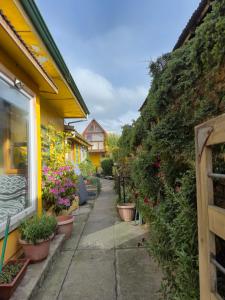 a garden path with plants in pots next to a building at Hotel de los Castillos in Puerto Natales