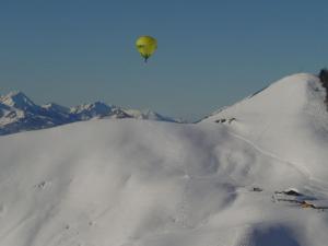 a hot air balloon flying over a snow covered mountain at Lockner Hütte in Schwaigs