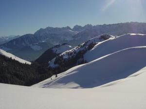 a group of people skiing down a snow covered mountain at Lockner Hütte in Schwaigs