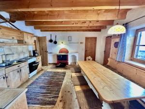 a large kitchen with a wooden table in a room at Lockner Hütte in Schwaigs