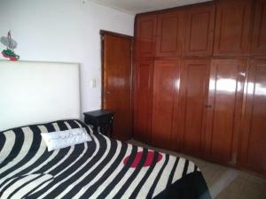 a bedroom with a bed and a wooden cabinet at Casa En Necochea 6 personas in Necochea