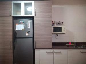 a kitchen with a black refrigerator and a microwave at Casa En Necochea 6 personas in Necochea