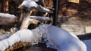 una fuente de agua cubierta de nieve junto a un edificio en Grasreithütte, en Schied