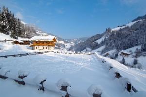 a building covered in snow in the mountains at Chalet Kleinbretteneben in Unterberg