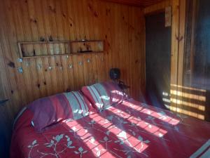 a bedroom with a bed in a wooden room at Casa completa en Horcón para 8 personas in Puchuncaví