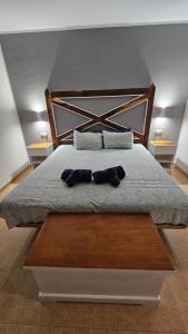 a bed with a wooden headboard and two pillows at Casa Galena in Corralejo