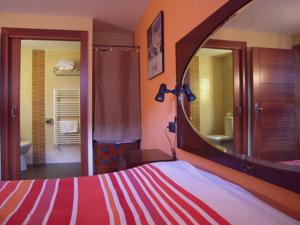 a bedroom with a bed with a large mirror at Casa Rural Apartamento El Chaveto in Herreros