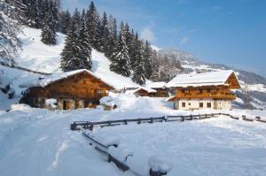 a snow covered log cabin with snow on the ground at Bretei Hüttn in Unterberg