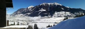 a snow covered mountain with a town in front of it at Koflerhäusl in Aigen