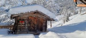 a log cabin with a wreath on it in the snow at Faschinghütte in Mühlbach am Hochkönig
