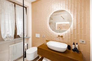 um banheiro com uma pia, um vaso sanitário e um espelho em Casa Nizza D'Oro em Castelnuovo mais 48 fotografias