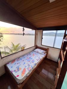 a bed in the back of a boat with two windows at Casa Lagoa da Diva in Maricá