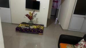 Una sala de estar con un jarrón con flores sobre una mesa. en casavaz, en Tarrafal