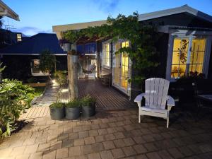 a white chair sitting on a brick patio at Zen Cabin in Mount Maunganui