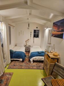 a bedroom with two beds and a mirror at Zen Cabin in Mount Maunganui