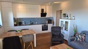 a kitchen and living room with a table and chairs at Roana apartment in Nałęczów