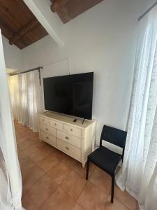 a living room with a tv and a chair and a dresser at Luxury Penthouse suite in Altos del Maria in Sorá