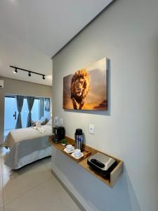 Un dormitorio con una pintura de un león en la pared. en Studio aconchegante com garagem privativa e varanda, en Montes Claros