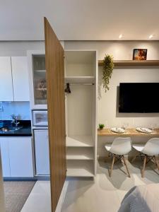 cocina pequeña con escritorio y mesa con sillas en Studio aconchegante com garagem privativa e varanda, en Montes Claros 34 fotos más