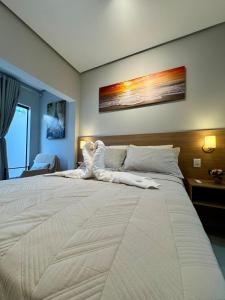 1 cama blanca grande en una habitación con en Studio aconchegante com garagem privativa e varanda, en Montes Claros