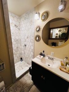 a bathroom with a sink and a shower with a mirror at Lakefront Getaway in Lone Oak