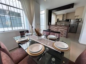 a dining room table with plates and glasses on it at Apartamento de lujo en Piura in Piura