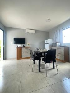 a kitchen with a table and chairs and a television at Flat Mirante da praia - piscinas naturais PE-AL in São José da Coroa Grande
