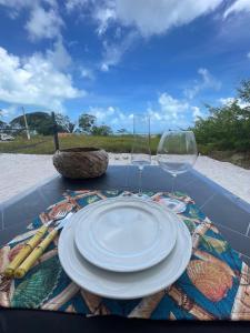 a table with a plate and two wine glasses on it at Flat Mirante da praia - piscinas naturais PE-AL in São José da Coroa Grande +9 photos